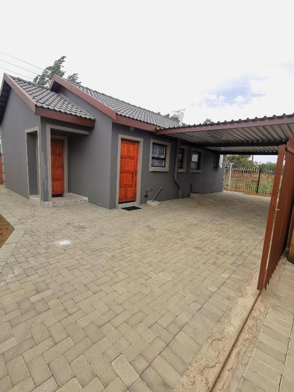 a house with orange doors and a patio at MV self-catering - Rooms in Bloemfontein