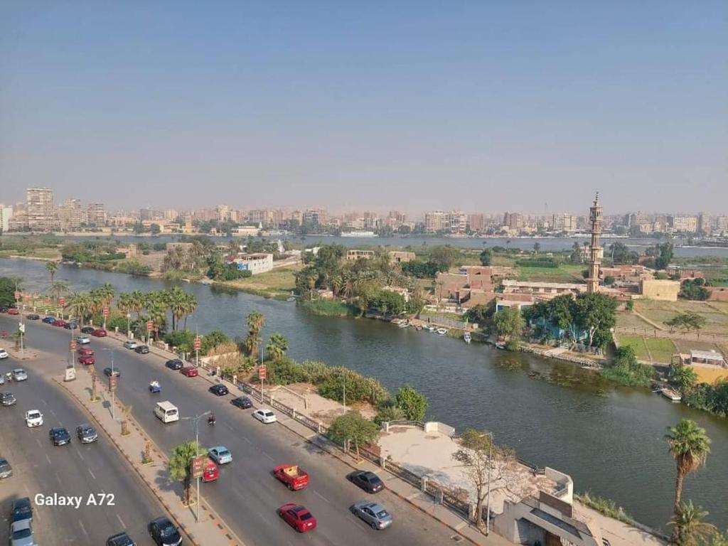 miasto z rzeką i samochodami na drodze w obiekcie شقة على النيل في البحر الاعظم w Kairze