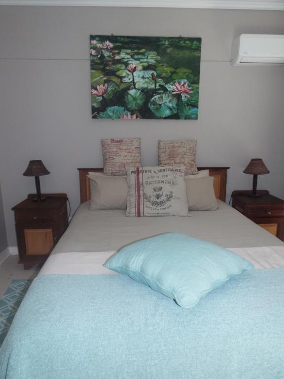 Una cama con una almohada azul encima. en Modern Comfy 2-Bedroom Self-catering Apartment - 1 minute walk to Strand beach en Strand