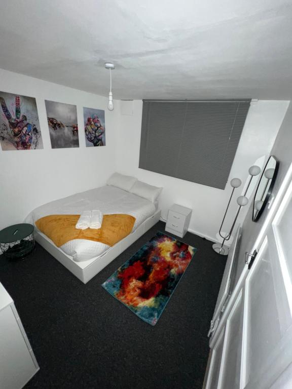 Dormitorio pequeño con cama y alfombra en a two bedroom cosy hideaway based in greenwich, en Londres