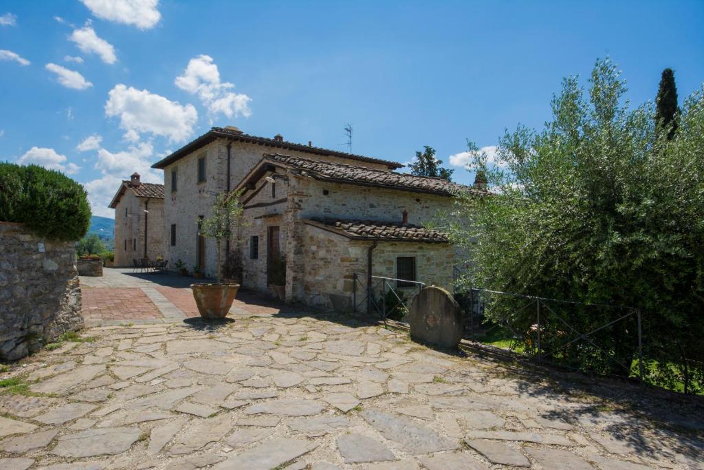 una antigua casa de piedra con una entrada de adoquines en Borgo Bottaia, en Grassina