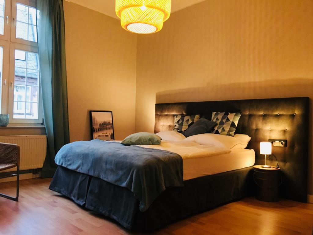 een slaapkamer met een groot bed en een kroonluchter bij Apartment am Bahnhof in Erfurt