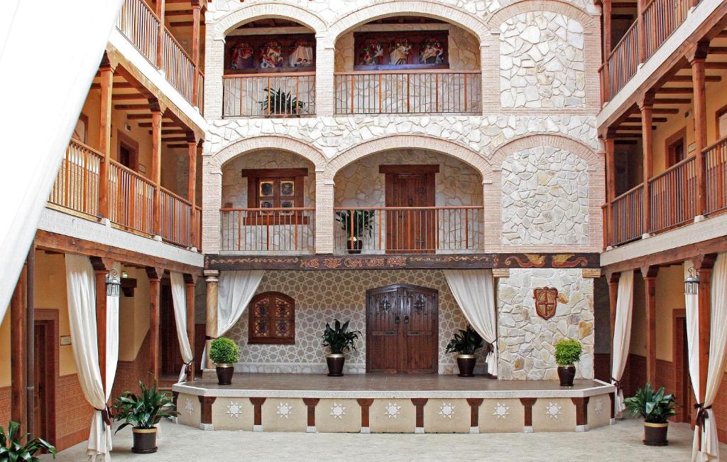 Apartamentos Rurales La Platea في إرفاس: مبنى كبير به شرفات وساحة بها نباتات الفخار