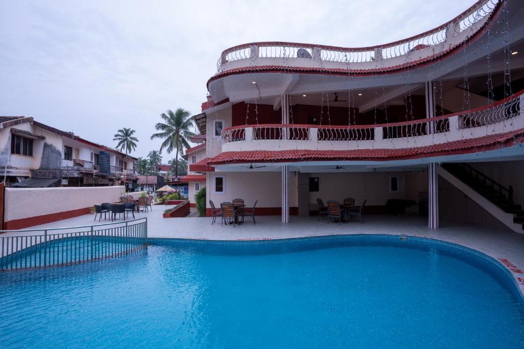 a large swimming pool in front of a building at Sunshine Resort Calangute Goa in Calangute