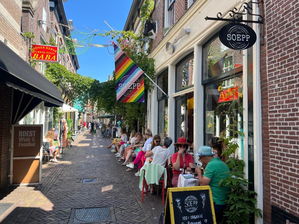 um grupo de pessoas sentadas em mesas numa rua em SOEPP the B&B em Alkmaar