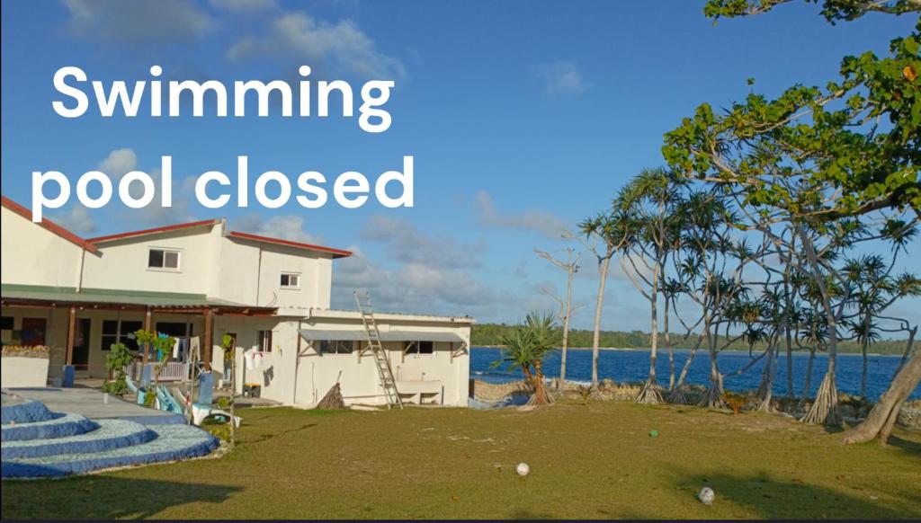 una casa vicino all'acqua con le parole piscina chiusa di Bluepango Guest House a Port Vila