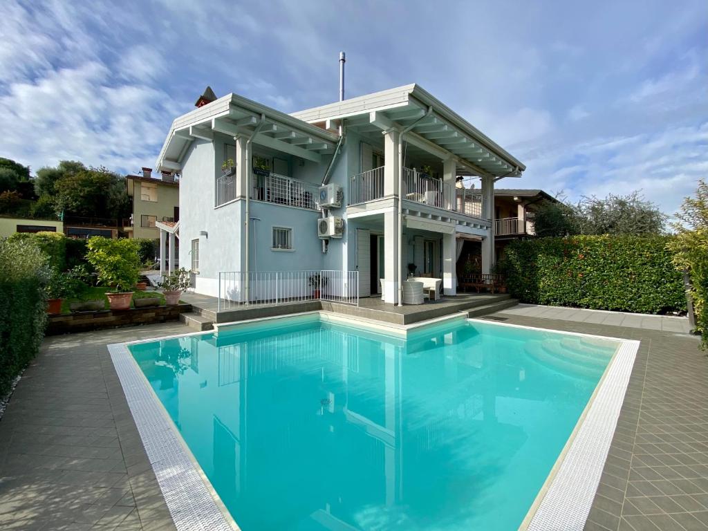 ein Haus mit einem Pool vor einem Haus in der Unterkunft Villa Chiara in Polpenazze del Garda