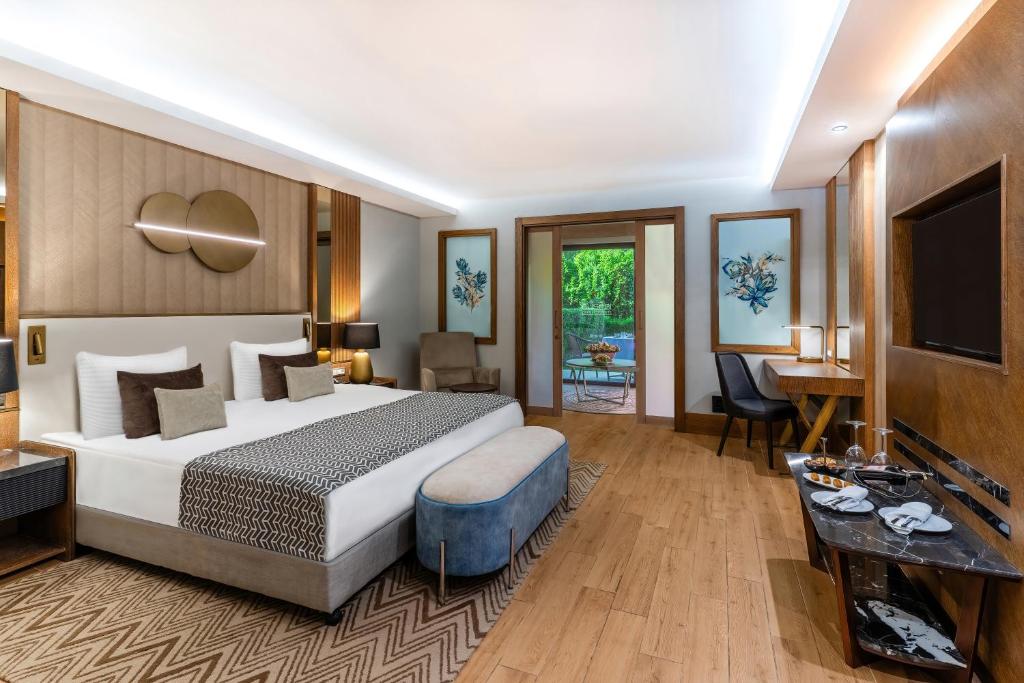 Habitación de hotel con cama y TV en Susesi Luxury Resort, en Belek
