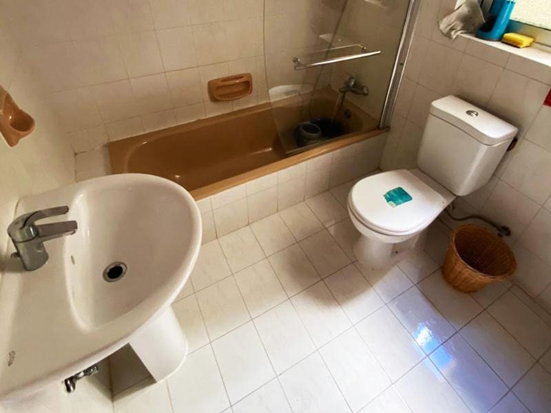 a bathroom with a sink and a toilet and a tub at EEM Only Girls Student Residence in Is-Swieqi