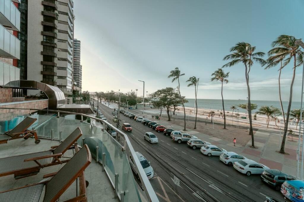 - une vue sur une rue avec des voitures garées sur la plage dans l'établissement Iracema Flat residence, à Fortaleza