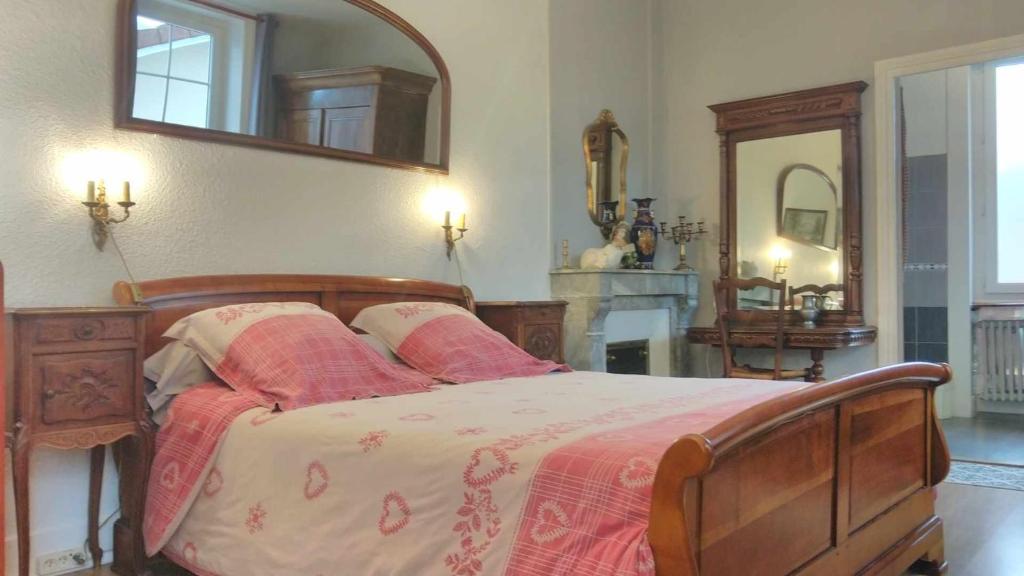 a bedroom with a bed and a mirror at A la Grenouille du Jura in Bellignat