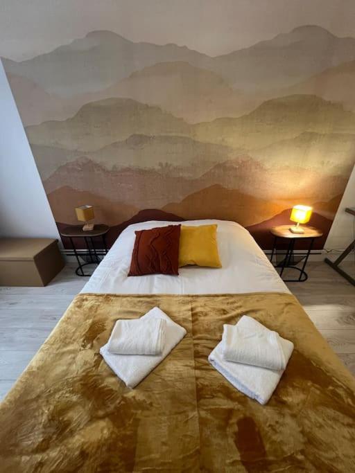 une chambre avec un lit avec deux oreillers dessus dans l'établissement Esprit Colmar - 2 chambres de charme, à Mulhouse