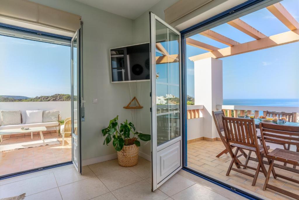 ein Wohnzimmer mit Glasschiebetüren, die auf eine Terrasse führen in der Unterkunft Aloha Apartment Arrifana in Arrifana Strand