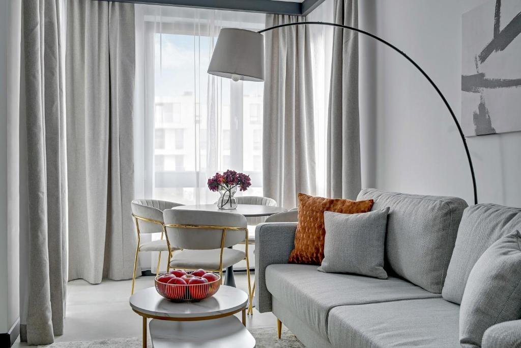 ソポトにあるNew Helsinki Luxury Residence Okrzei 19 by Lion Apartments Sopotのソファとテーブルのあるリビングルーム