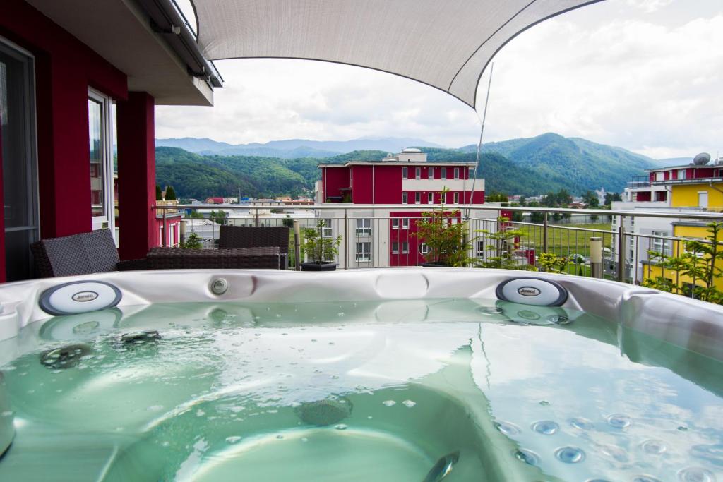 a hot tub on a balcony with a view at Brasov Penthouse Retreat in Braşov