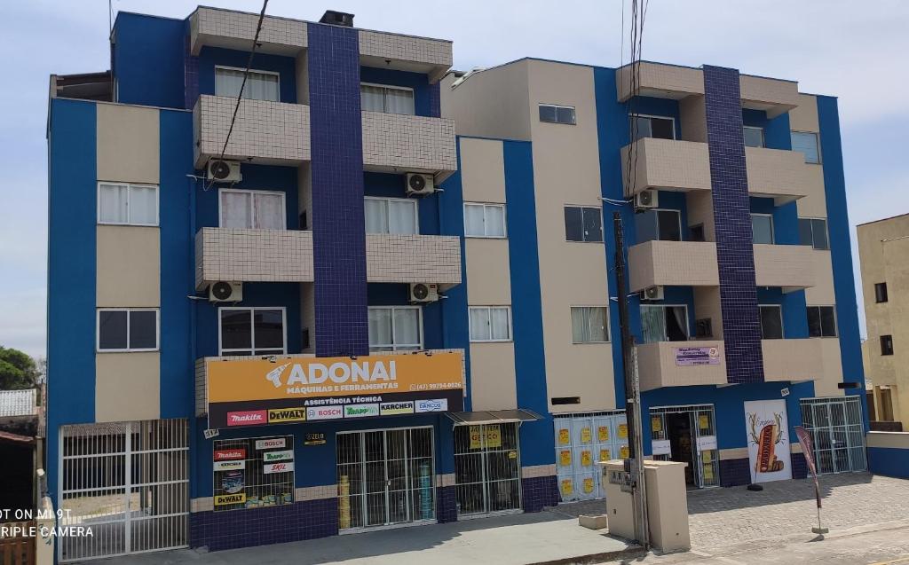 a tall building with a kawi sign in front of it at Residencial Oceano Azul in Itapoa