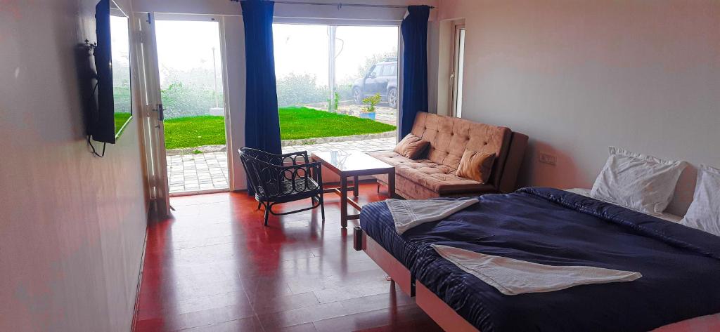 科代卡那的住宿－HappyHuts at Green valley view，一间卧室配有一张床、一张沙发和一张桌子