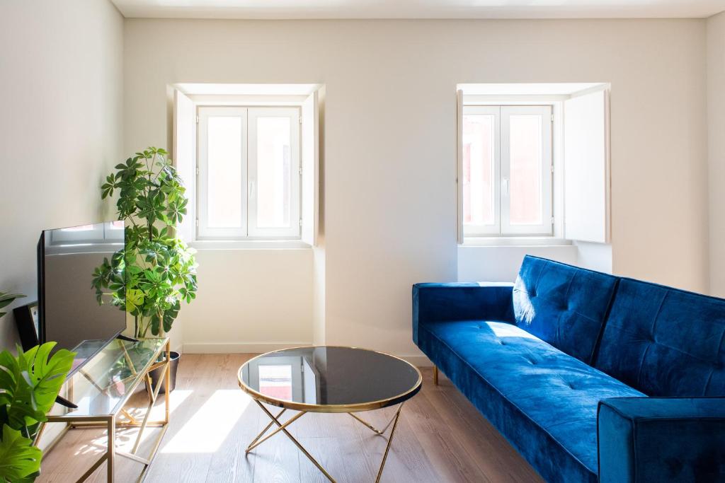 uma sala de estar com um sofá azul e uma mesa em Pardal RC A - Luxury 2 Bed Apartment in Alcantara em Lisboa