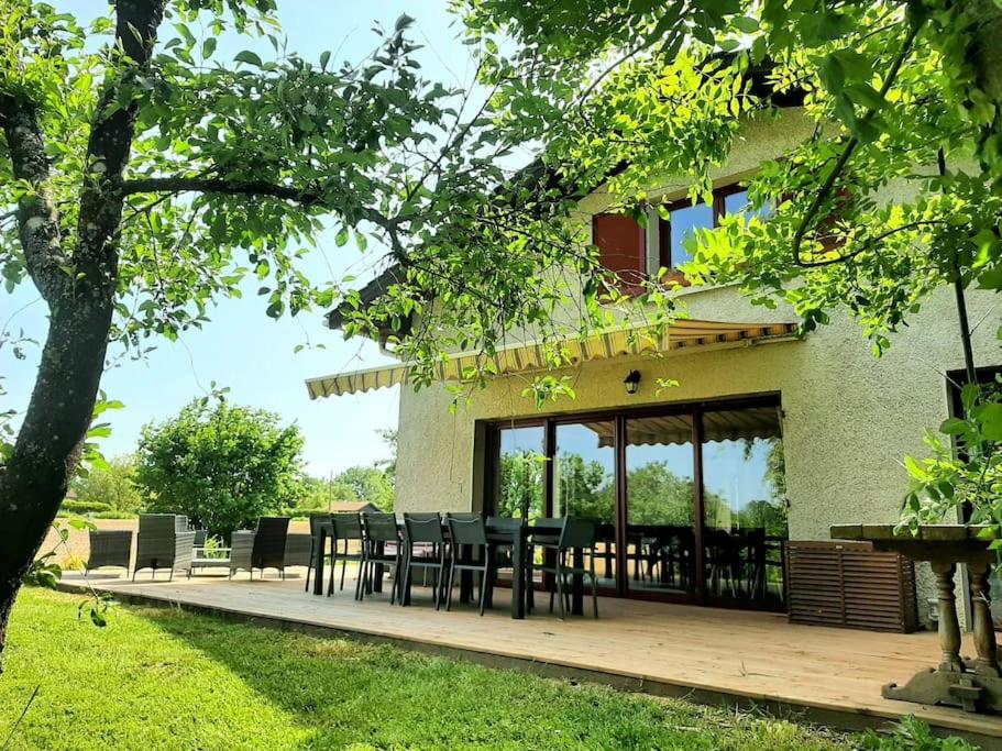 une terrasse avec des tables et des chaises en face d'une maison dans l'établissement jolie maison de campagne à 100 m de l'étang, à Rhodes