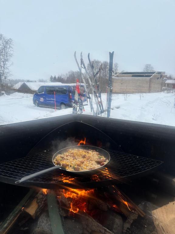 a pan of food is cooking on a grill at Granlunda Fjällgård in Duved