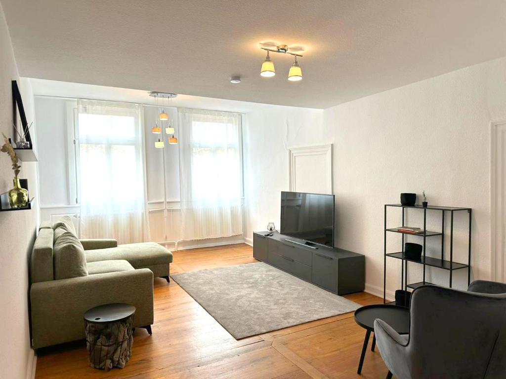 een woonkamer met een bank en een tv bij Charmante Altbauwohnung in Erlangen