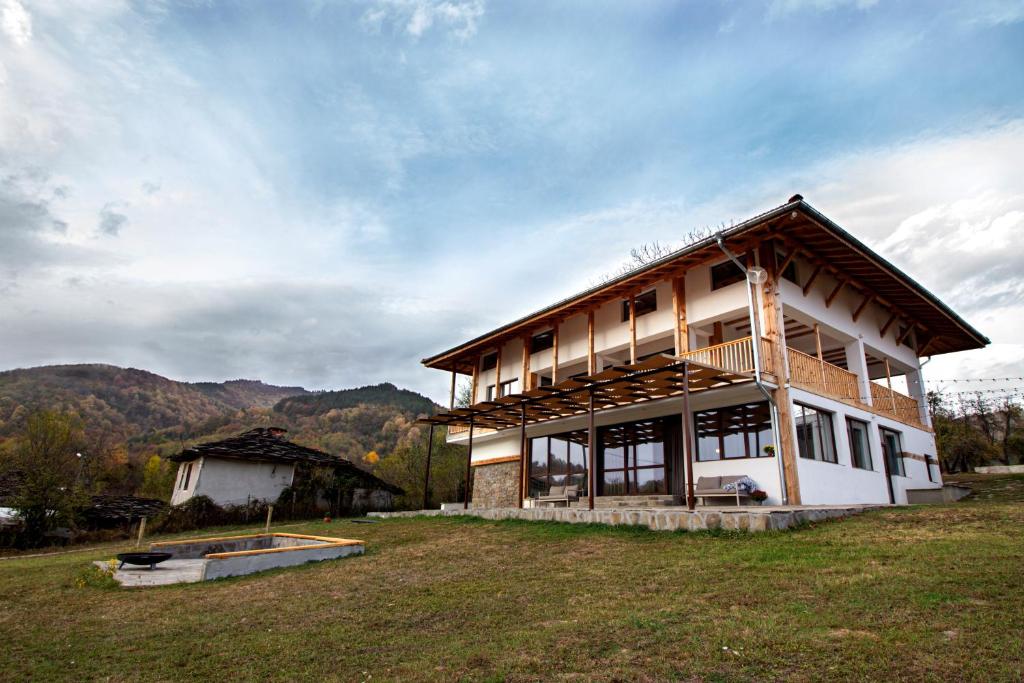 ein Haus auf einem Feld neben einem Gebäude in der Unterkunft Villa Oreh Kravenik - Вила Орех Кръвеник in Kravenik