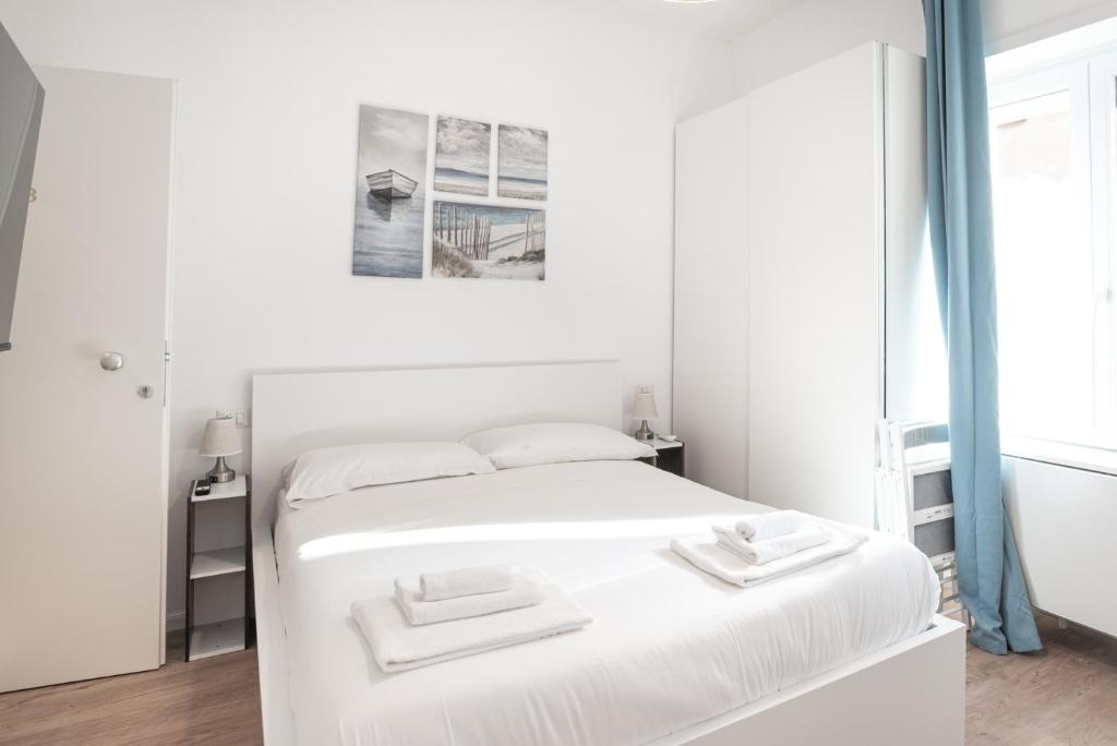 ein weißes Schlafzimmer mit einem Bett mit zwei Handtüchern darauf in der Unterkunft Residence San Paolo in Rom