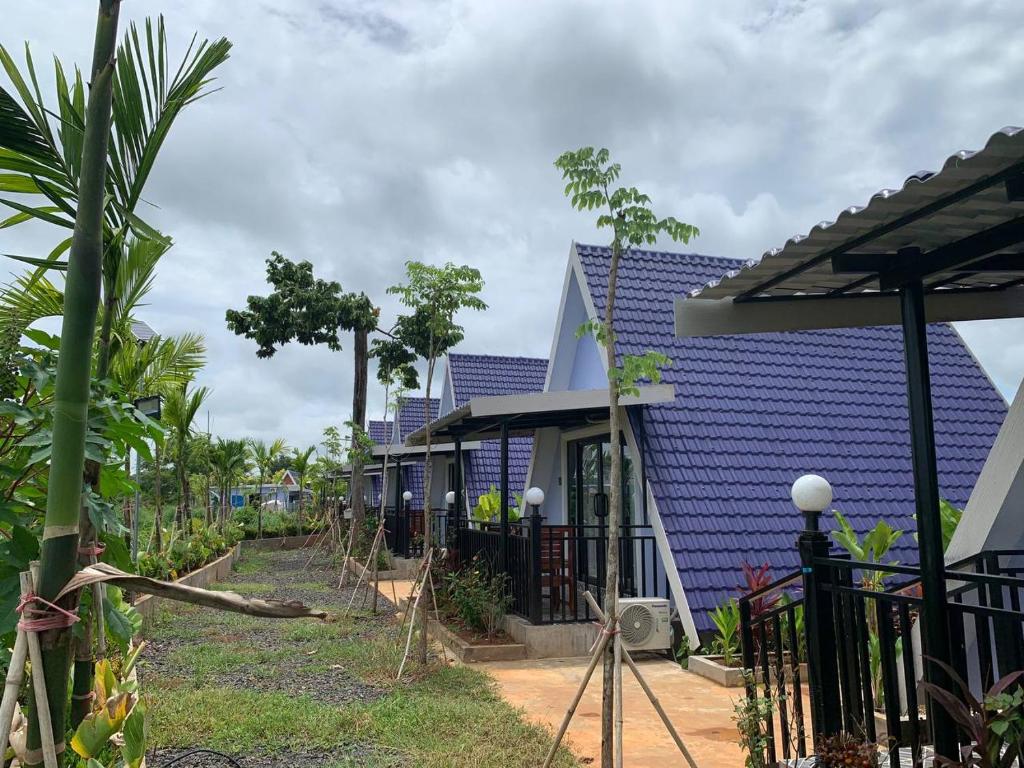 une rangée de maisons aux toits bleus dans l'établissement I AM Koh Ker, à Phumĭ Mréch