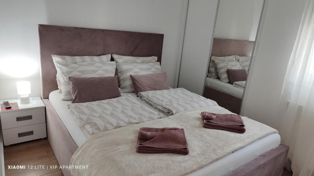 een slaapkamer met een bed met twee handdoeken erop bij VIP Apartment in Jagodina