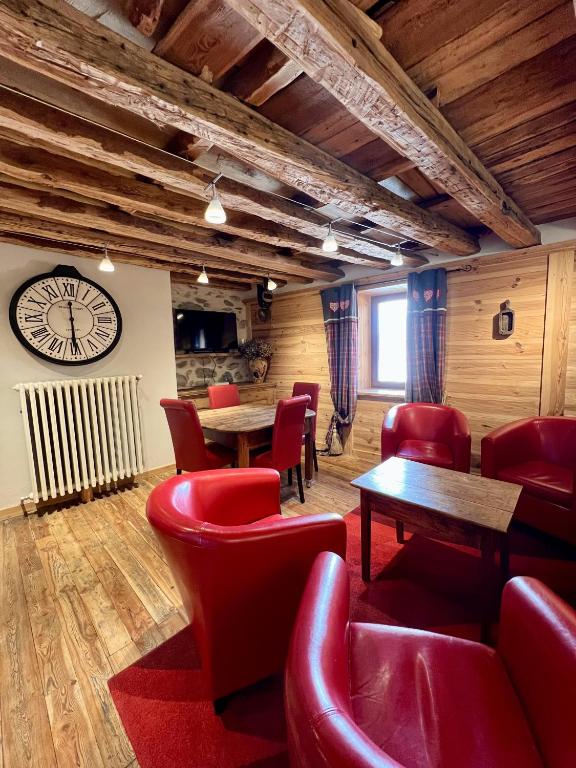 a restaurant with red chairs and tables and a clock at Appartement Esprit Chalet 71m² in Briançon