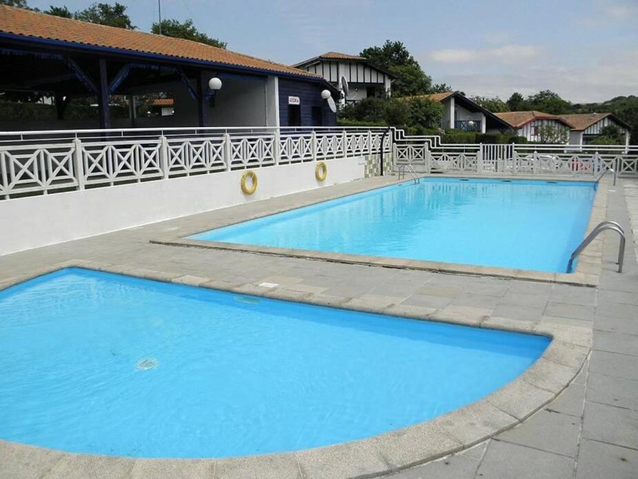 2 grandes piscinas azules junto a un edificio en INIGO, en Hendaya