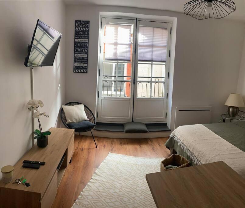 um quarto com uma cama, uma secretária e uma televisão em Chez Renata (Hyper centre) em Dieppe