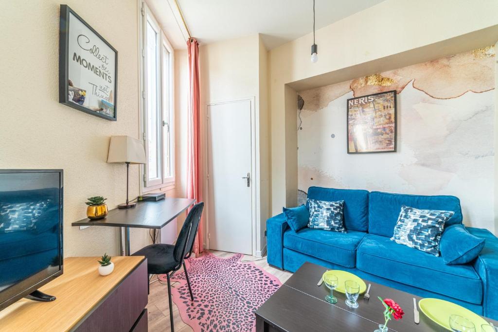 - un salon avec un canapé bleu et une table dans l'établissement Le Studio Nérisien - Studio pour 2, à Néris-les-Bains