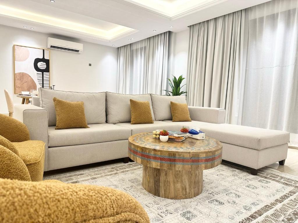 a living room with a couch and a coffee table at Luxurious 3 Bedroom Apartment - 5 minutes to Boulevard in Riyadh