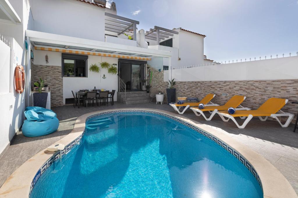 une villa avec une piscine et une maison dans l'établissement Villa Crown22, à Quarteira