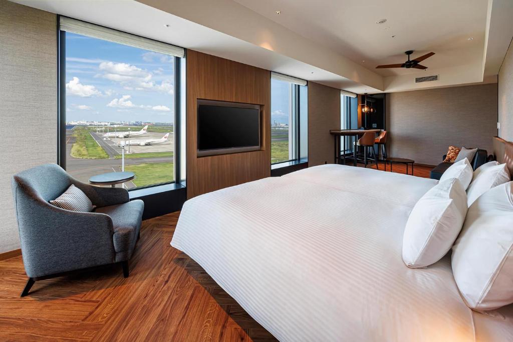 een grote slaapkamer met een groot bed en een televisie bij Hotel Metropolitan Tokyo Haneda - 2023-10-17 Grand Opening in Tokyo