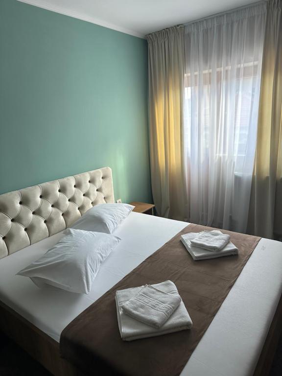 a bedroom with a large bed with two towels on it at Freedom&Relax in Buzău
