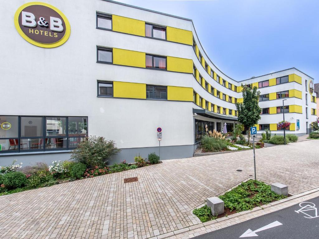 un edificio con un edificio amarillo y blanco en B&B Hotel Schweinfurt-City en Schweinfurt