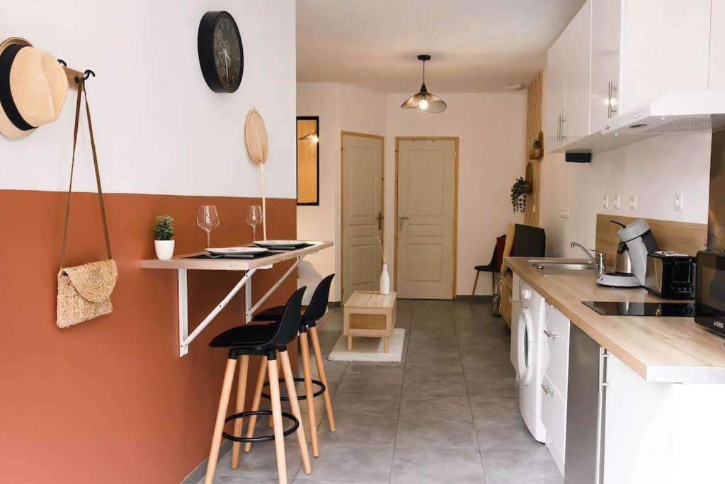 uma cozinha com um balcão e bancos num quarto em T2 Idéalement Situé * Hyper Centre/Canal Plus * em Amiens