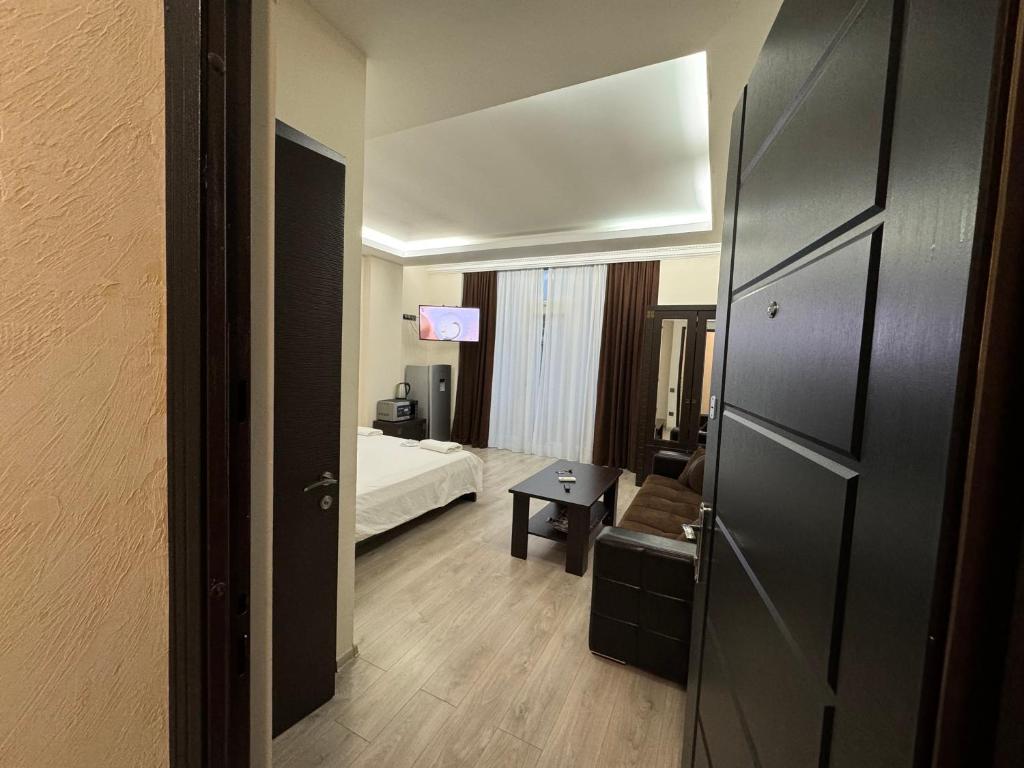 a room with a bedroom with a bed and a table at Iko's Family Apartments in Batumi