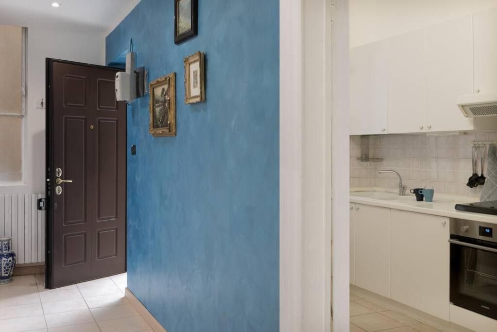 Una pared azul en una cocina con puerta en Central Station Monza - Affitti Brevi Italia en Monza