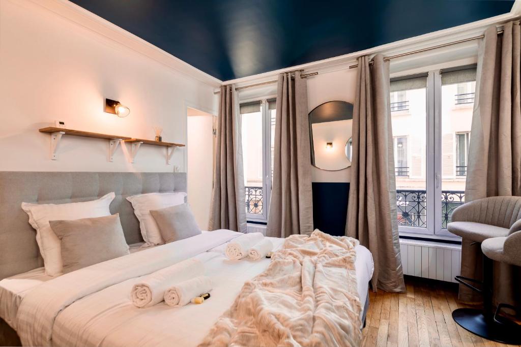 a bedroom with a large bed with towels on it at Cute Studio in the 16th near the Arc de Triomphe in Paris