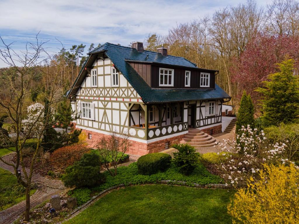 une maison blanche et noire avec un toit vert dans l'établissement BnB Rauschenberg, à Rauschenberg