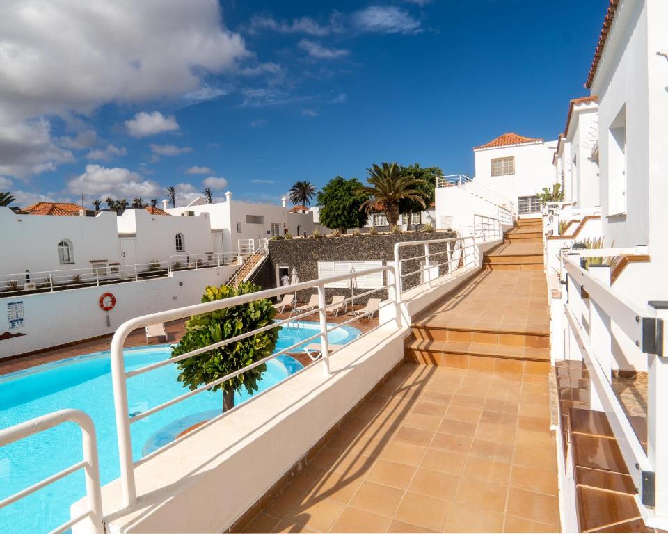 a view of the balcony of a building with a swimming pool at Las Casitas de Corralejo in Corralejo