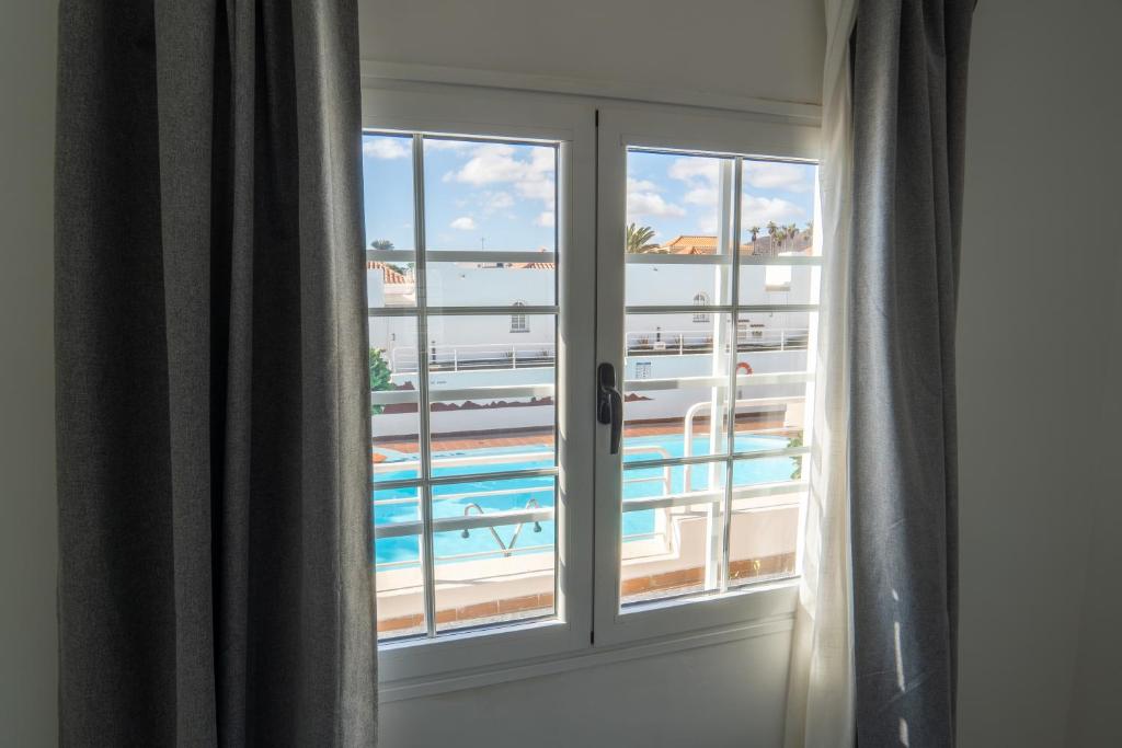 a window with a view of a swimming pool at Las Casitas de Corralejo in Corralejo
