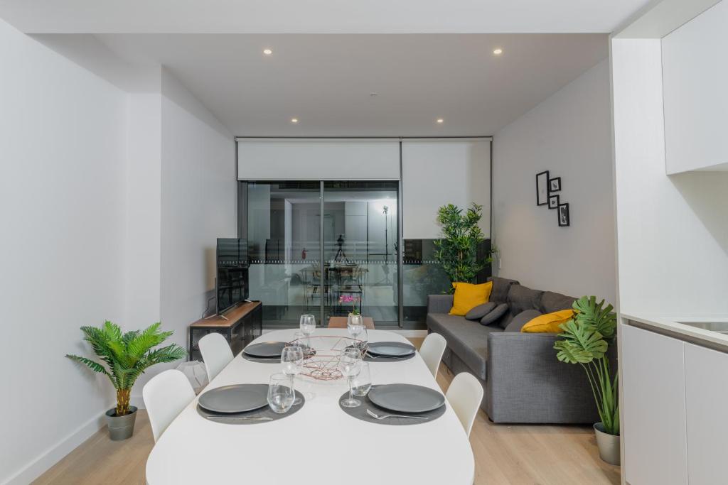 a living room with a white table and a couch at Modern 2 Bedroom Apartment Darling Square in Sydney