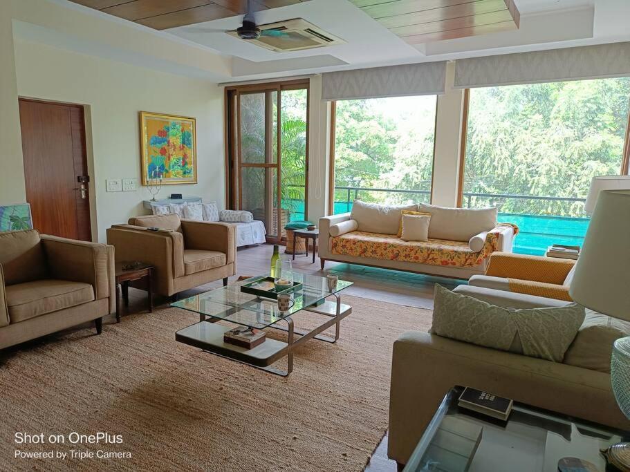 un ampio soggiorno con divani e tavolo di Pristine home near New Friends colony a Nuova Delhi
