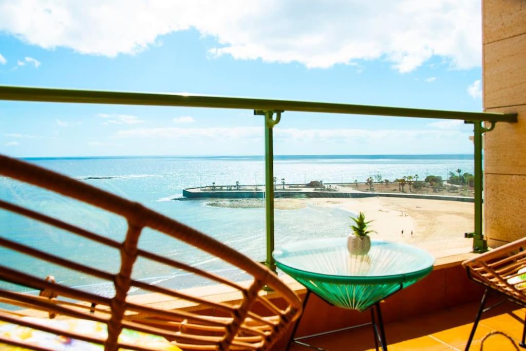 a balcony with a table and a view of the beach at Beachfront arrecife views in Arrecife