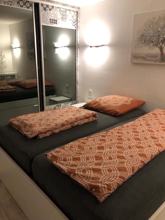 - une chambre avec 2 lits et un miroir dans l'établissement Wunderschönes 2 Zimmer Apartment Zentrum Goldstadt, à Pforzheim