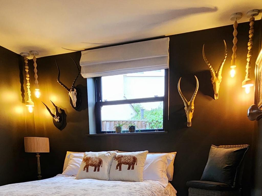 a bedroom with a bed with antlers on the wall at La Casa Rossa with free parking in Cheltenham